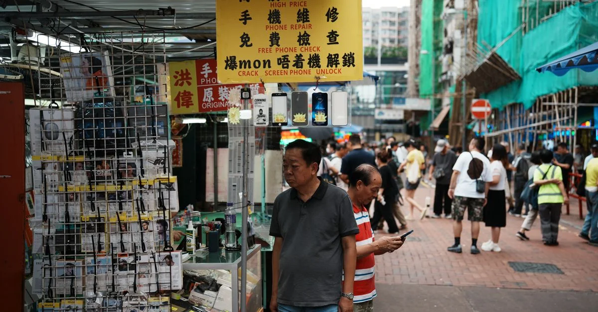 Scène de rue animée montrant un atelier de réparation de téléphones et des passants dans un environnement de marché urbain.