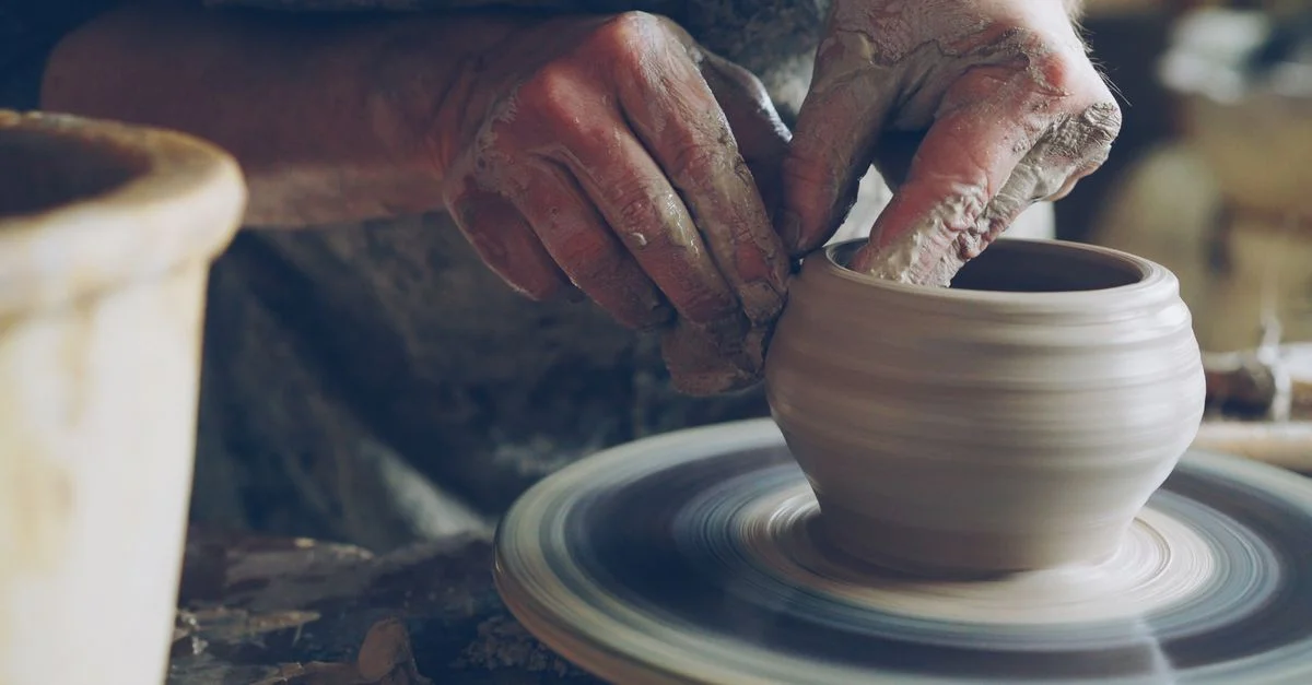 Un artisan façonne habilement l'argile sur un tour de potier, démontrant ainsi des techniques de poterie traditionnelles.